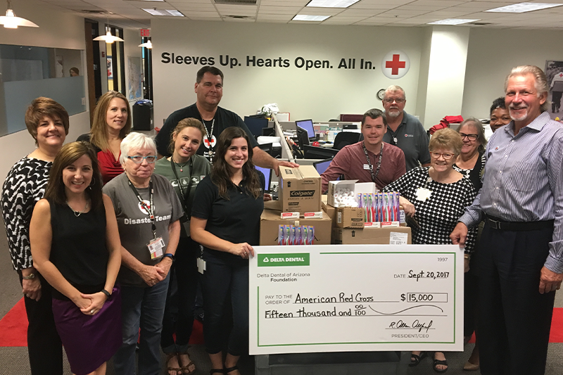 Group of American Red Cross employees smiling and holding a life size grant check from Delta Dental of Arizona 