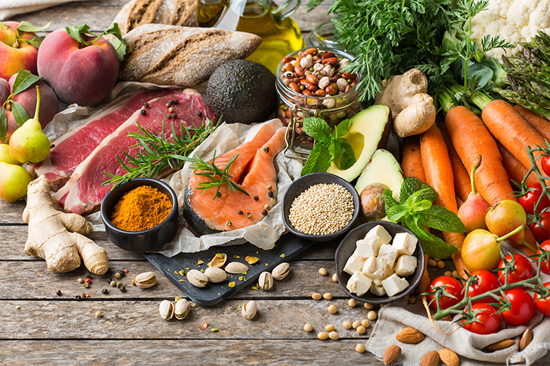 Mouth-healthy foods like vegetables, fruits and proteins elegantly displayed across a table 