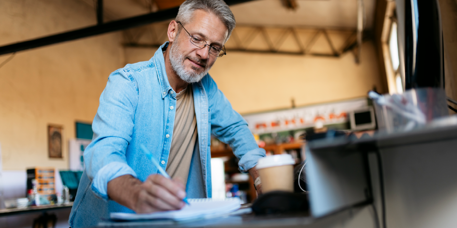 Man in casual business attire writing 