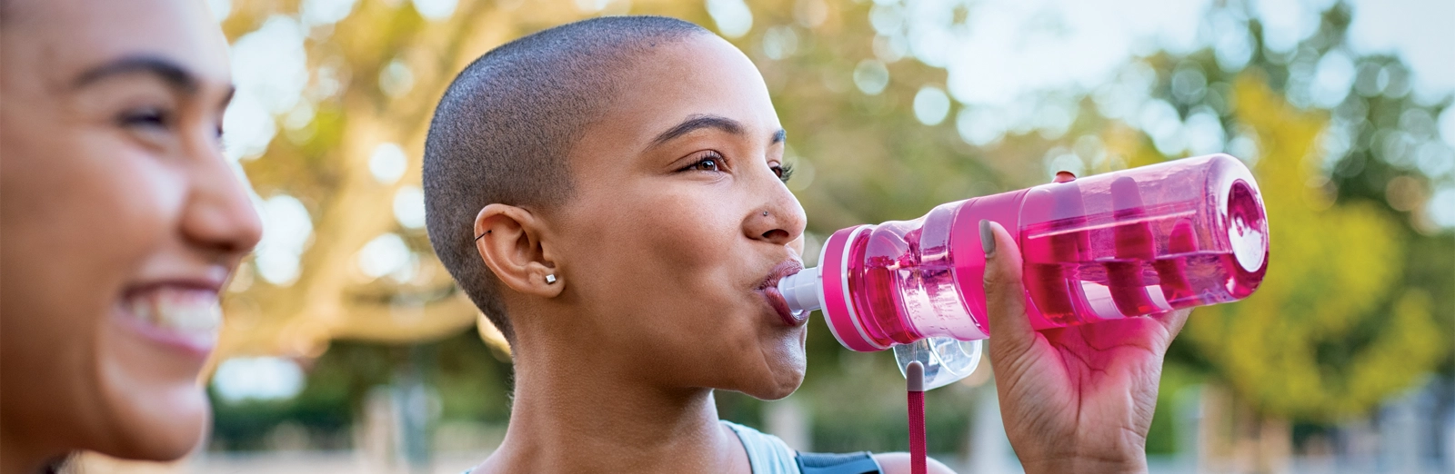 woman-drinking-from-pink-water-bottle-1600x522.webp